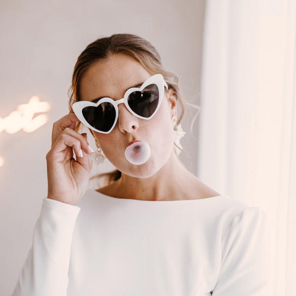 Braut mit Sonnenbrille und Kaugummiblase