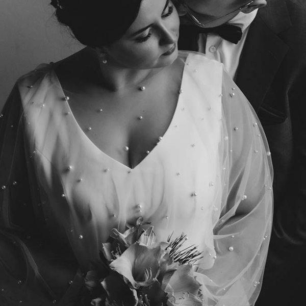 Brautpaar mit Perlen besetzten Brautkleid und Anzug mit Fliege