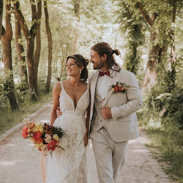 Brautkleid mit tiefen V-Ausschnitt und Hochzeitsanzug in beige