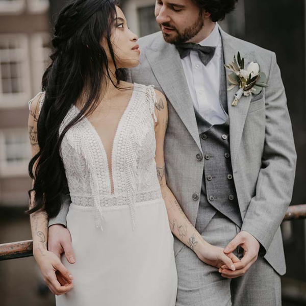 Brautpaar mit Fransen-Brautkleid und grauen Anzug