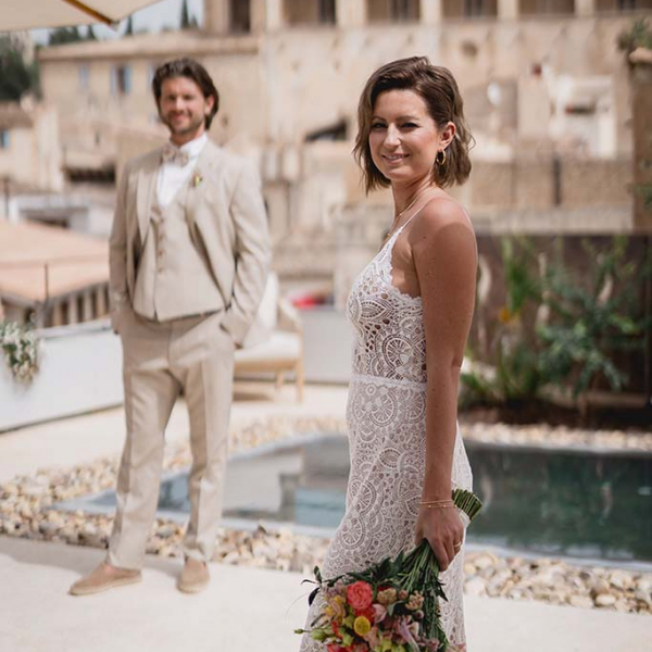 Brautpaar mit eng anliegenden Brautkleid und beigen Hochzeitsanzug