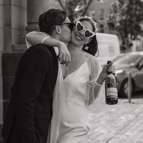 Brautpaar mit Sektflasche