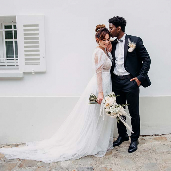 Braut mit verträumten Brautkleid und Bräutigam in schwarzen Anzug